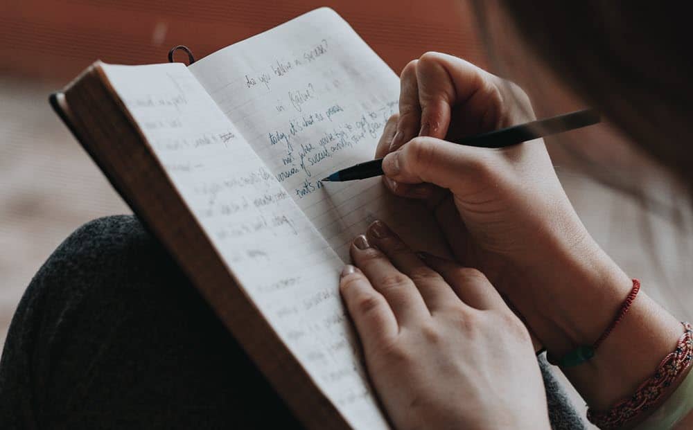 A young woman writing in a journal