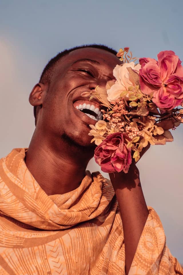 photo of man smiling while holding flowers 3400738